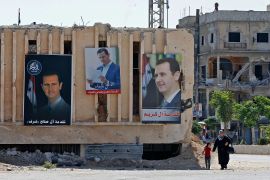 Portraits of Syrian President Bashar al-Assad are hung on buildings at a polling station in Douma, near the capital Damascus on May 26, 2021. LOUAI BESHARA/AFP VIA GETTY IMAGES