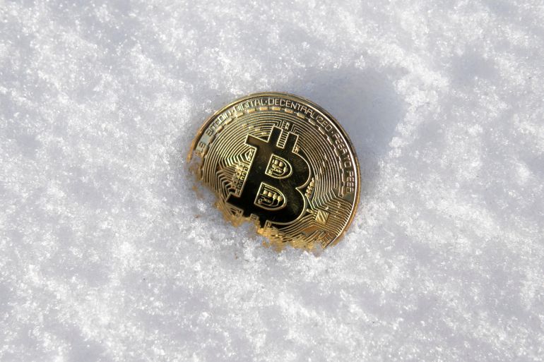 Bitcoin. Cryptocurrency on snow, in the background. The concept of freelancing, the stock exchange. Gold bitcoin on cold winter snow background. Frozen bitcoin. Frozen account. Cryptocurrency trading. shutterstock_1038215053