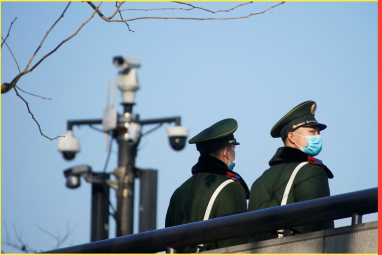 .Paramilitary police members wearing protective face masks stand near surveillance cameras at the Bund, following new cases of the coronavirus disease (COVID-19), in Shanghai, China January 20, 2022. REUTERS/Aly Song