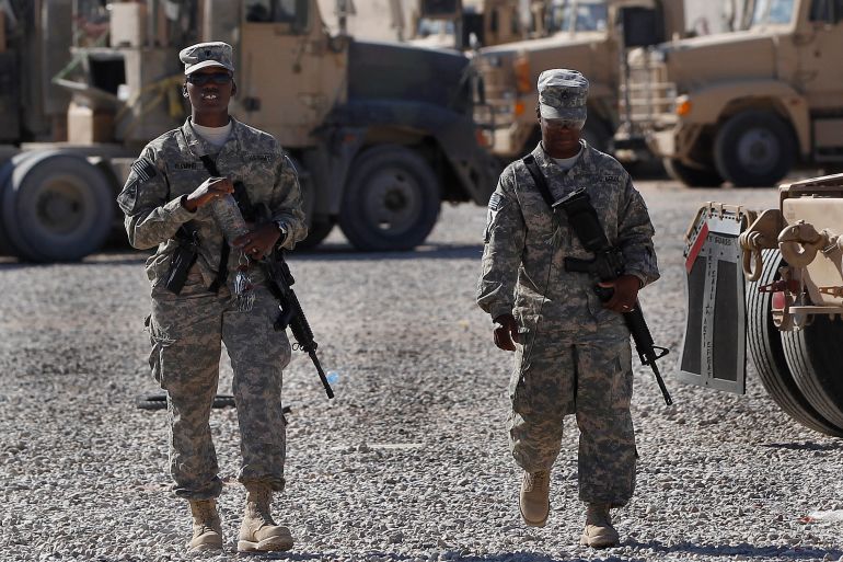 U.S. Army soldiers walk through a vehicle transport area inside Camp Adder, near Nasiriyah, Iraq