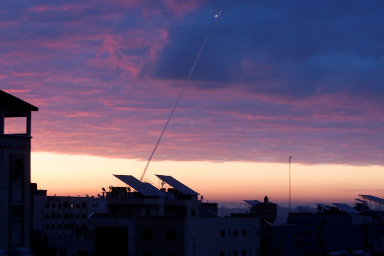 Trails of smoke are seen as rockets are fired from Gaza towards Israel during the sunrise