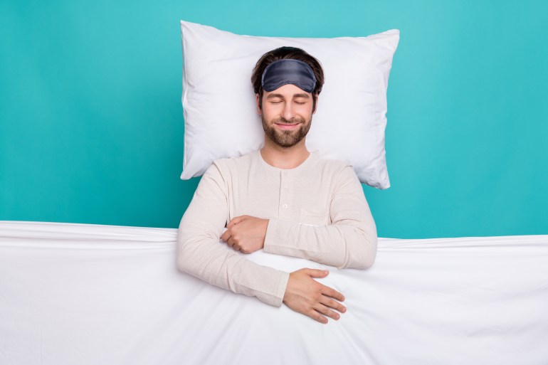 Top above high angle view photo of young man happy positive smile bed sleep cover blanket wear pajama isolated over teal color background; Shutterstock ID 2019739502; purchase_order:ب; job:; client:; other: