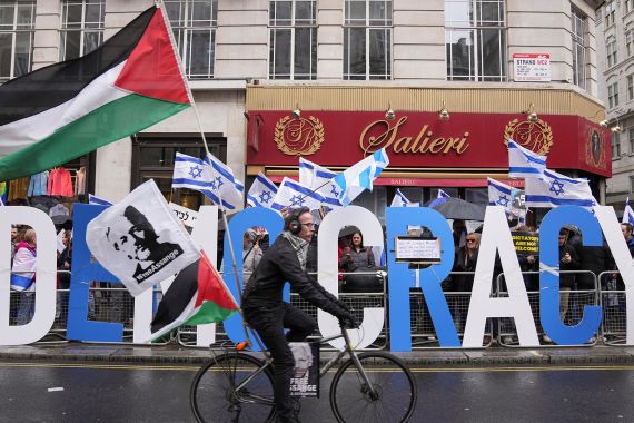 A man rides a bike with Palestinian flags next to demonstrators with Israeli flags during a protest against Israeli Prime Minister Benjamin Netanyahu as he visits Britain, in London, Britain March 24, 2023. REUTERS/Maja Smiejkowska