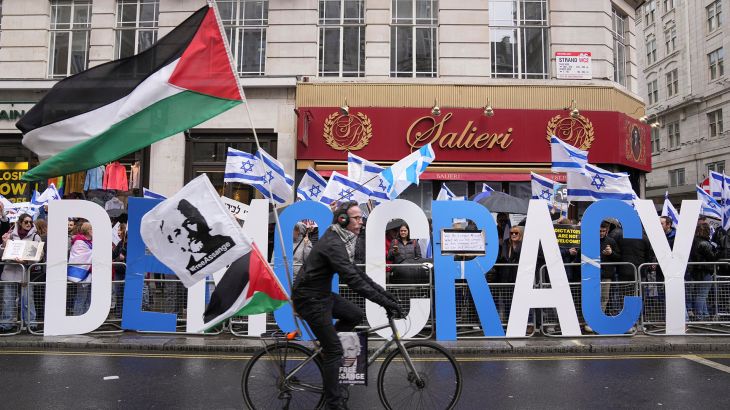 A man rides a bike with Palestinian flags next to demonstrators with Israeli flags during a protest against Israeli Prime Minister Benjamin Netanyahu as he visits Britain, in London, Britain March 24, 2023. REUTERS/Maja Smiejkowska