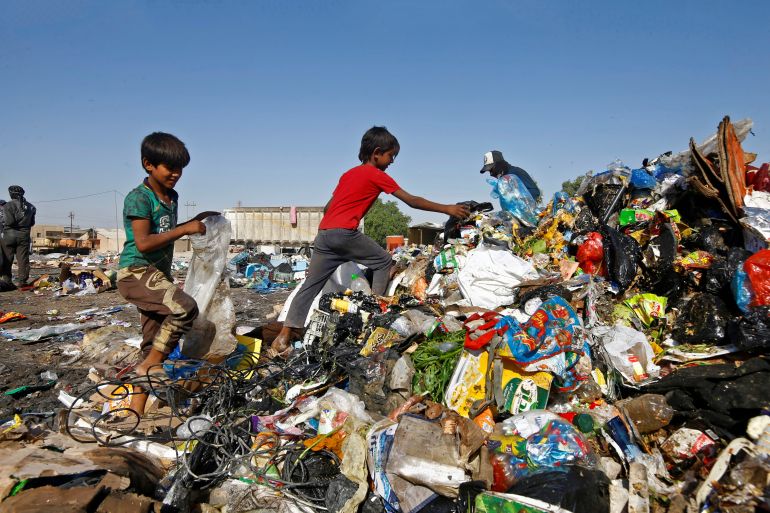 FILE PHOTO: Iraqi boys collect recyclable garbage at a dump in the holy city of Najaf, Iraq October 23, 2020. Picture taken October 23, 2020. REUTERS/Alaa Al-Marjani/File Photo