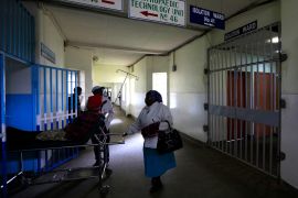 A patient is wheeled on a stretcher next to an isolation ward set aside for Ebola related cases at the Kenyatta National Hospital (KNH) in the capital Nairobi