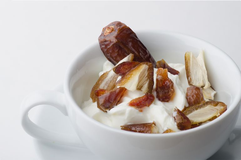 plain yogurt with dates in a cup shutterstock_418500985