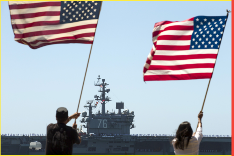 Supporters wave American flags along the shoreline as the USS Ronald Reagan, a Nimitz-class nuclear-powered super carrier, departs for Yokosuka, Japan from Naval Station North Island in San Diego, California August 31, 2015. The Reagan is replacing the USS George Washington as part of a complicated three-carrier swap that exchanges crews for ships, saving the Navy millions in moving costs. REUTERS/Mike Blake TPX IMAGES OF THE DAY