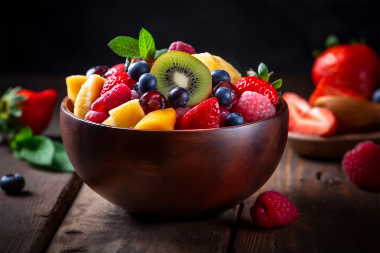 Bowl of healthy fresh fruit salad on wooden background - المصدر: ميدجيرني