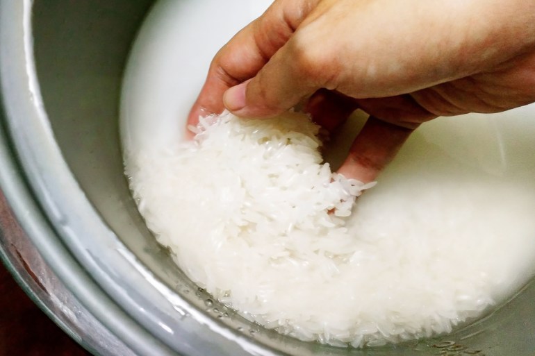Washing jasmine rice in a rice pot - stock photo washing jasmine rice in a rice pot gettyimages-547242480