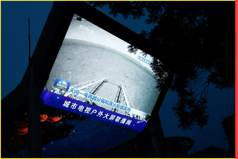 A screen broadcasts a CCTV state media news bulletin, showing an image of Mars taken by Chinese Mars rover Zhurong as part of the Tianwen-1 mission, in Beijing, China, May 19, 2021. REUTERS/Thomas Peter REFILE - CORRECTING INFORMATION