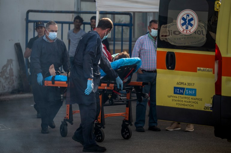 Medical staffs carry a survivor on a stretcher outside a warehouse at the port in Kalamata town, on June 15, 2023, after a boat carrying dozens of migrants sank in international waters in the Ionian Sea. - Greece has declared three days of mourning, the interim prime minister's office said on June 14, 2023, over a migrant boat sinking in the Ionian Sea feared to have claimed hundreds of lives. The Greek coastguard has so far recovered 79 bodies and rescued over 100, but survivors are claiming that up to 750 people were on board. (Photo by Angelos TZORTZINIS / AFP)