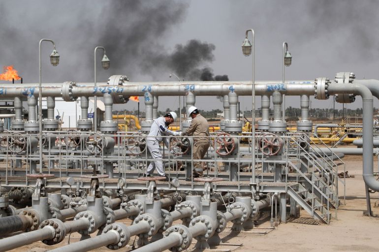 Workers adjust the valve of an oil pipeline at Nahr Bin Umar oil field, north of Basra, Iraq March 22, 2022. REUTERS/Essam Al-Sudani REFILE - QUALITY REPEAT