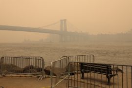 The Williamsburg Bridge is seen covered in haze and smoke caused by wildfires in Canada, in Brooklyn, New York
