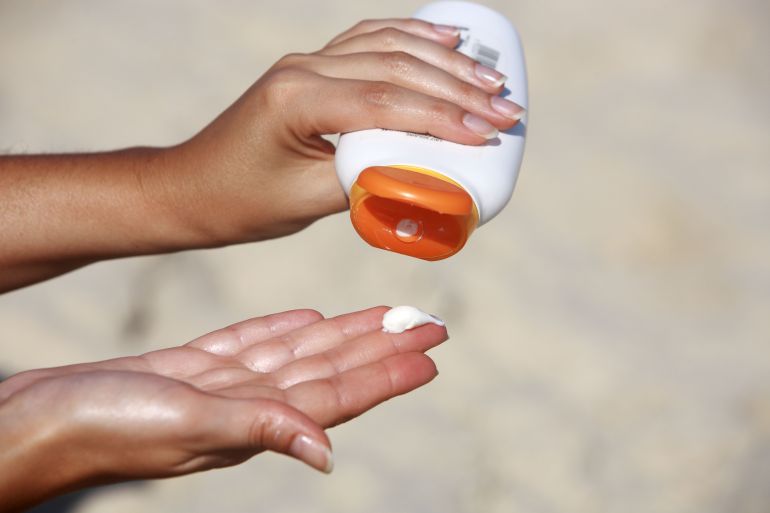 close up of women hands receiving sunblock cream lotio