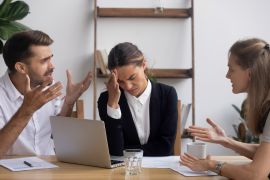 Stressed annoyed office employee manager having headache migraine at business meeting with complaining client customer tired of angry colleagues arguing shouting having conflict dispute at workplace