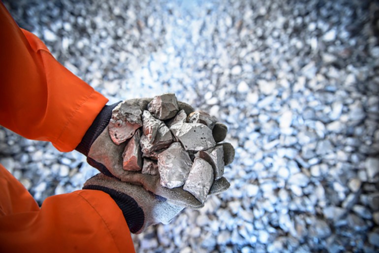 Close up of workers hands holding crushed titanium - stock photo