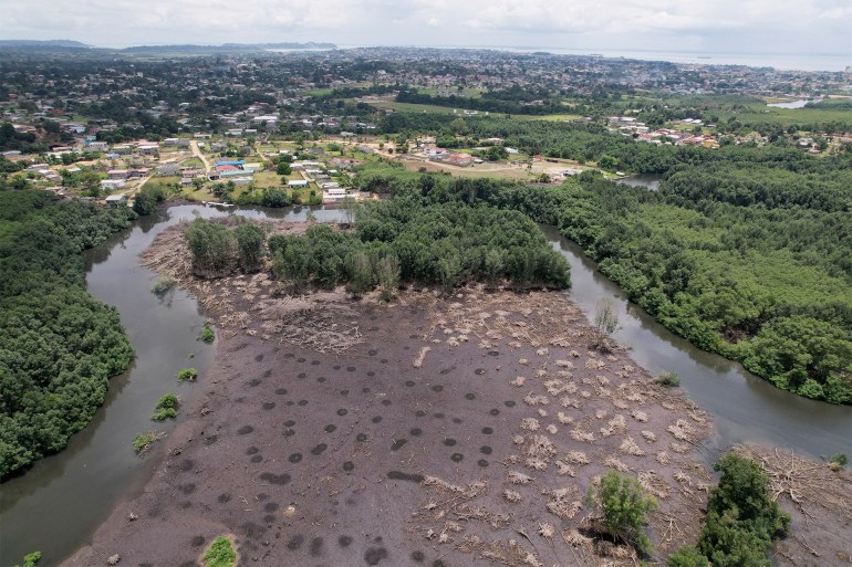 FILE PHOTO: An aerial view shows a mangrove field that has been cleared to make space for new constructions, in the Mindoube 1 neighborhood, in Libreville, Gabon October 17, 2021. Picture taken October 17, 2021. Picture taken with a drone. REUTERS/Christophe Van Der Perre/File Photo