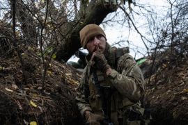 Slavian, a former Russian special forces sergeant who now fights for Ukraine after living in the country for a decade with his Ukrainian wife, gestures to keep quiet as he moves along front-line tenches toward a Russian position in Zaporizhzhia, Ukraine, on Oct. 27, 2022. CARL COURT/GETTY IMAGES