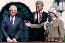 PLO Chairman Yasser Arafat (R) gestures to Israeli Prime Minister Yitzhak Rabin (L), as U.S. President Bill Clinton stands between them, following their handshake after the signing of the Israeli-PLO peace accord, at the White House in Washington September 13, 1993. REUTERS/Gary Hershorn (UNITED STATES - Tags: POLITICS)