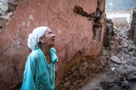 A woman reacts standing infront of her earthquake-damaged house in the old city in Marrakesh on September 9, 2023. - A powerful earthquake that shook Morocco late September 8 killed more than 600 people, interior ministry figures showed, sending terrified residents fleeing their homes in the middle of the night. (Photo by FADEL SENNA / AFP)