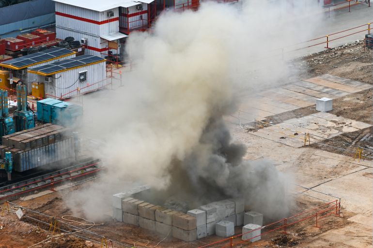 Smoke rises after a 100kg World War II-era aerial bomb is detonated at a construction site in Singapore on September 26, 2023. (Photo by Roslan RAHMAN / AFP)