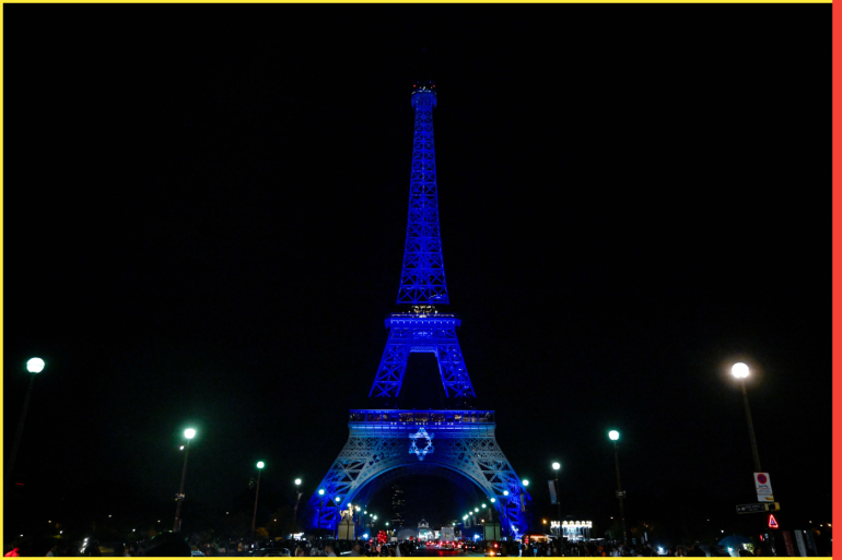 This photograph taken on October 9, 2023 shows the Eiffel Tower illuminated with the Star of David and the colours of national flag of Israel, in tribute to the victims of the recent Hamas attacks. - RESTRICTED TO EDITORIAL USE - MANDATORY MENTION OF THE ARTIST UPON PUBLICATION - TO ILLUSTRATE THE EVENT AS SPECIFIED IN THE CAPTION (Photo by JULIEN DE ROSA / AFP) / RESTRICTED TO EDITORIAL USE - MANDATORY MENTION OF THE ARTIST UPON PUBLICATION - TO ILLUSTRATE THE EVENT AS SPECIFIED IN THE CAPTION