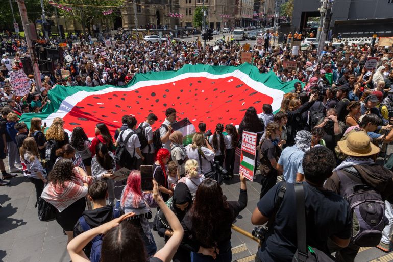 متظاهرون يحملون علمًا كبيرًا على شكل بطيخ في محطة شارع فليندرز في ملبورن، أستراليا من أجل فلسطين "