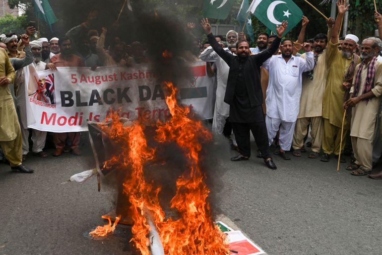 People burn an effigy of India's Prime Minister Narendra Modi during a protest to mark the fourth anniversary of abrogation of the special status of Jammu and Kashmir by the Indian government, in Lahore on August 5, 2023. (Photo by Arif ALI / AFP)