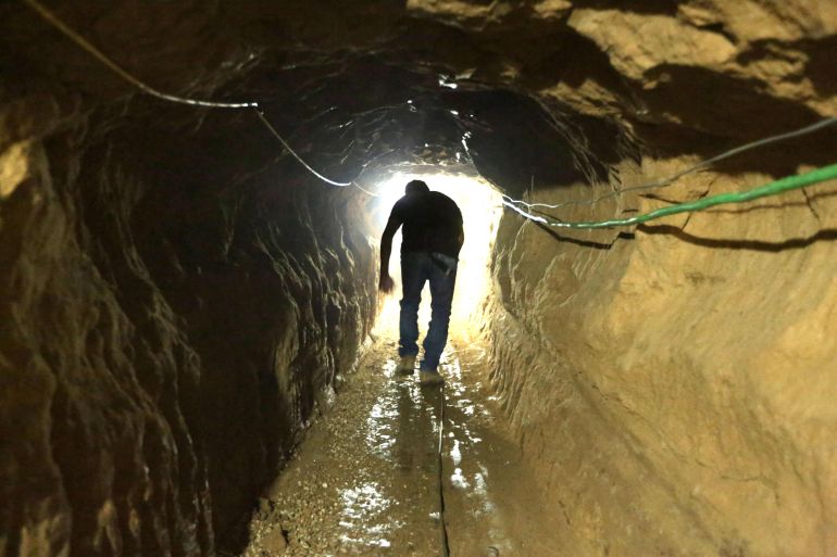 (FILES) A Palestinian man walks from the Egyptian side of the border in a repaired bombed smuggling tunnel linking the Gaza Strip to Egypt, in Rafah, on November 29, 2012. A sprawling network of Hamas tunnels under the Gaza Strip has become a primary target for the Israeli military in its stated mission to defeat the Palestinian militants, experts say. (Photo by Patrick BAZ / AFP)