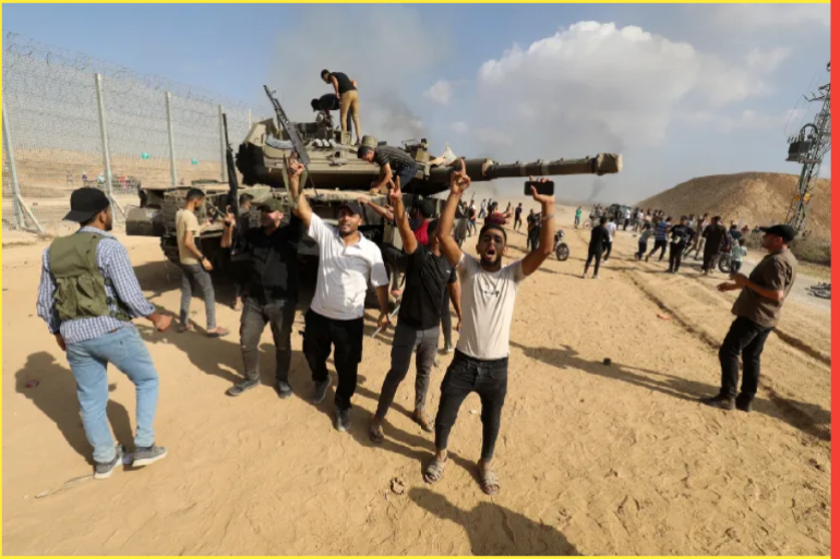 مقاتلو كتائب القسام يحتفلون على أنقاض دبابة إسرائيلية (وكالة الأناضول)
