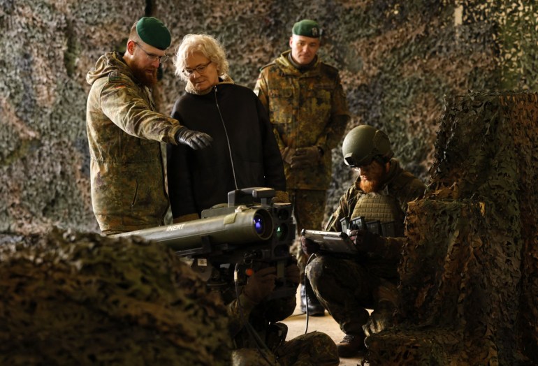 German Defence Minister Christine Lambrecht listens to explanations about the anti tank system MELLS that is used wit the armoured "Marder" vehicle, as the commander of the armored infantryman batallion 371, lieutenant Thomas Spranger (2ndR) looks on during her visit at the military base of an armored infantryman batallion in Marienberg, eastern Germany, on January 12, 2023. Germany will supply Ukraine with about 40 Marder infantry fighting vehicles within weeks as part of a new phase of support coordinated with the US. (Photo by Odd ANDERSEN / AFP)