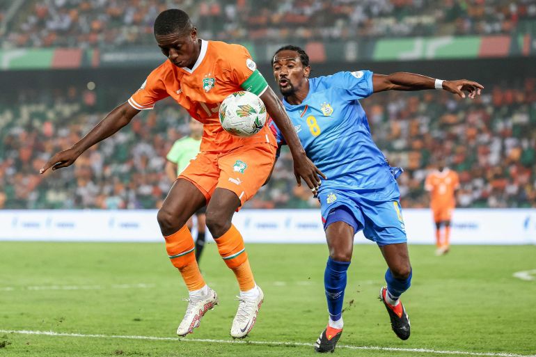 Ivory Coast's forward #15 Max-Alain Gradel (L) fights for the ball with DR Congo's midfielder #8 Samuel Moutoussamy during the Africa Cup of Nations (CAN) 2024 semi-final football match between Ivory Coast and Democratic Repuplic of Congo at Alassane Ouattara Olympic Stadium in Ebimpe, Abidjan on February 7, 2024. (Photo by FRANCK FIFE / AFP)