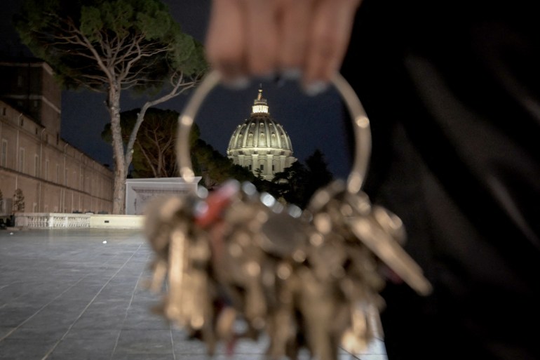 The cuppola of St.Peter's basilica is seen through the ring of a big mast of keys held by Gianni Crea, key keeper of the Vatican Museums, during a private visit of the museums by night, on February 13, 2024. (Photo by Tiziana FABI / AFP)