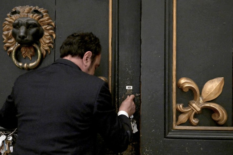 Gianni Crea, key keeper of the Vatican Museums, open a wooden door during a private visit of the museums by night, early on February 13, 2024. (Photo by Tiziana FABI / AFP)