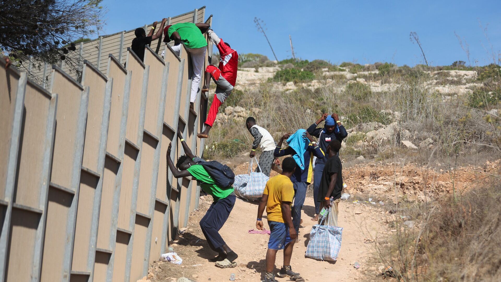 مهاجرن يفرون من مركز النقطة الساخنة في لمبيدوزا (رويترز)