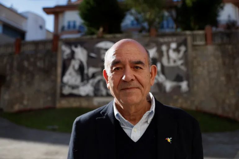 Raji Sourani, a Palestinian human rights lawyer from Gaza, stands in front of a reproduction of Pablo Picasso's antiwar painting Guernica in Guernica, Spain [File: Vincent West/Reuters]