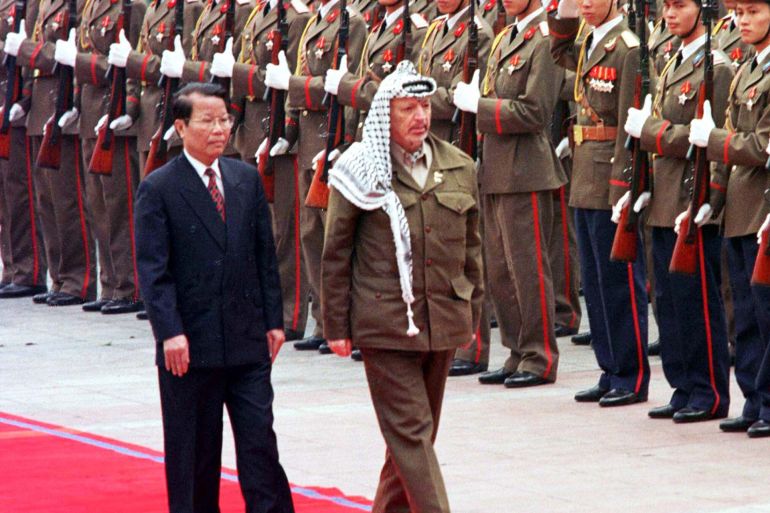 Palestinian President Yasser Arafat inspects an honour guard with Vietnamese President Tran Duc Luong in Hanoi in 1999 [File: AFP]