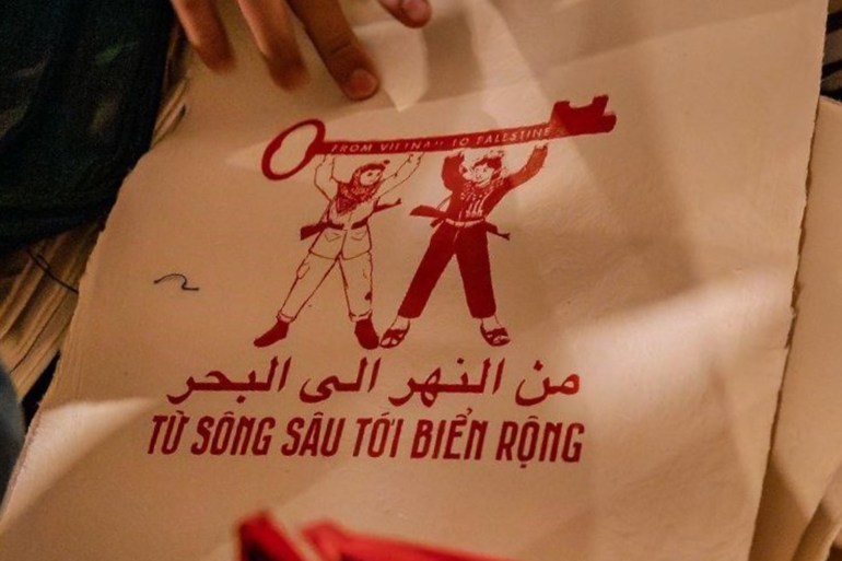 Pro-Palestinian artwork on display in Hanoi features a fighter from the Vietnamese national liberation struggle and a Palestinian fighter above the words in Arabic and Vietnamese: "From the river to the sea" [Courtesy of Cat Nguyen]