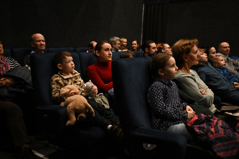 Families wait for the beginning of a slide show in a cinema in Budapest on February 18, 2024, as the Hungarian 'Diafilmgyarto' celebrates its 70th anniversary with various events including monthly screenings of slide films at a Budapest cinema attracting dozens of children and nostalgic adults. - A century-old storytelling medium, its Hungarian producer has seen a resurgence in demand for filmstrips since the 2000s as enthusiasts appreciate the chance for slower, more intimate storytelling in the age of increasingly fast-paced entertainment. Filmstrips -- sometimes called slide films -- are printed on rolls of film, but unlike traditional movies, images can be shown for any amount of time, and are not meant to create the illusion of motion. (Photo by ATTILA KISBENEDEK / AFP) / TO GO WITH AFP STORY BY ANDRAS ROSTOVANYI - TO GO WITH AFP STORY by Andras ROSTOVANYI