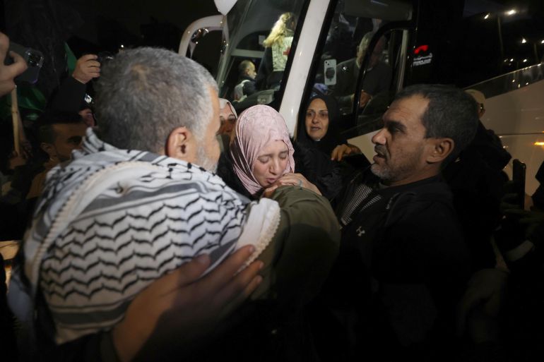 RAMALLAH, WEST BANK - NOVEMBER 28: People hug each other as 33 Palestinians, including 3 children and 30 women, released from Israeli jail arrive in Beitunia, Ramallah, West Bank by a bus belonging to the International Committee of the Red Cross (ICRC) on November 28, 2023. (Photo by Issam Rimawi/Anadolu via Getty Images)