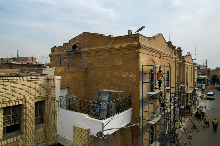 مجموعة من الأعمال يقومون بترميم مبنى المتحف العراقي الإيطالي (الجزيرة نت))