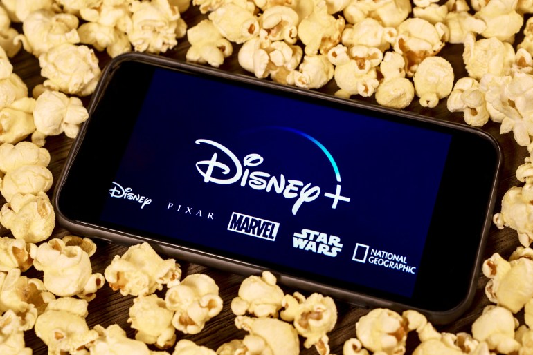 Grand Prairie, TX/USA - Aug 2019: Disney Plus on smartphone with popcorn. Dinsey+ is a new streaming subscription service that will feature Marvel, Pixar, Star Wars, and National Geographic content