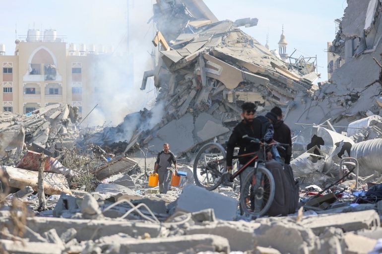 Palestinians walk through the rubble of destroyed residential buildings in Qatari-funded Hamad City, following an Israeli raid, amid the ongoing conflict between Israel and Hamas, in Khan Younis in the southern Gaza Strip March 13, 2024. REUTERS/Ahmed Zakot