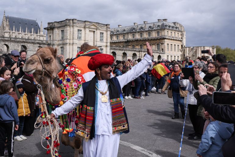 An Indian camel driver takes part in a camelids parade 'the Amazing parade' in front of the Chateau de Vincennes near Paris, on April 20, 2024. - On April 19, 2024, the Paris Administrative Court upheld a decision by the Prefecture of Police to ban a parade of some fifty camels, dromedaries, llamas and alpacas planned for April 20 in the area around the Eiffel Tower. (Photo by ALAIN JOCARD / AFP)