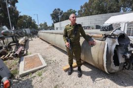 المتحدث العسكري الإسرائيلي يقف بجوار صاروخ باليستي إيراني سقط خلال الهجوم (الفرنسية)